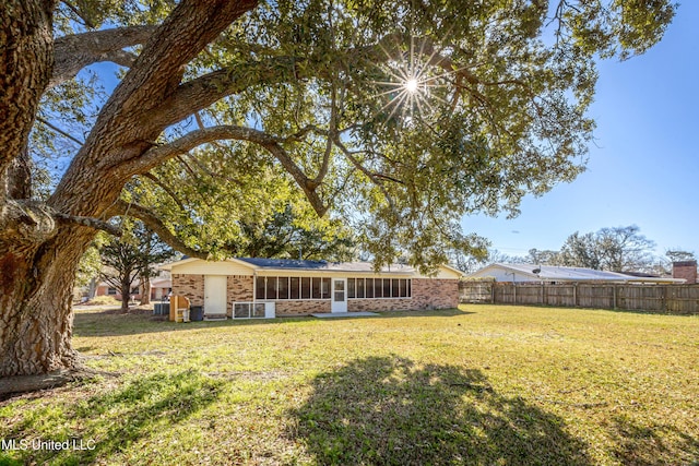 view of yard with fence and a sunroom