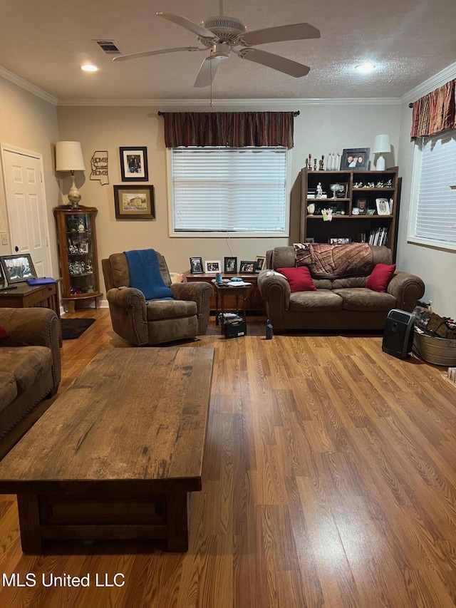 living room featuring wood-type flooring, ornamental molding, and ceiling fan