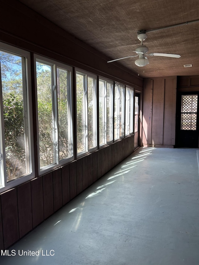 unfurnished sunroom with a ceiling fan