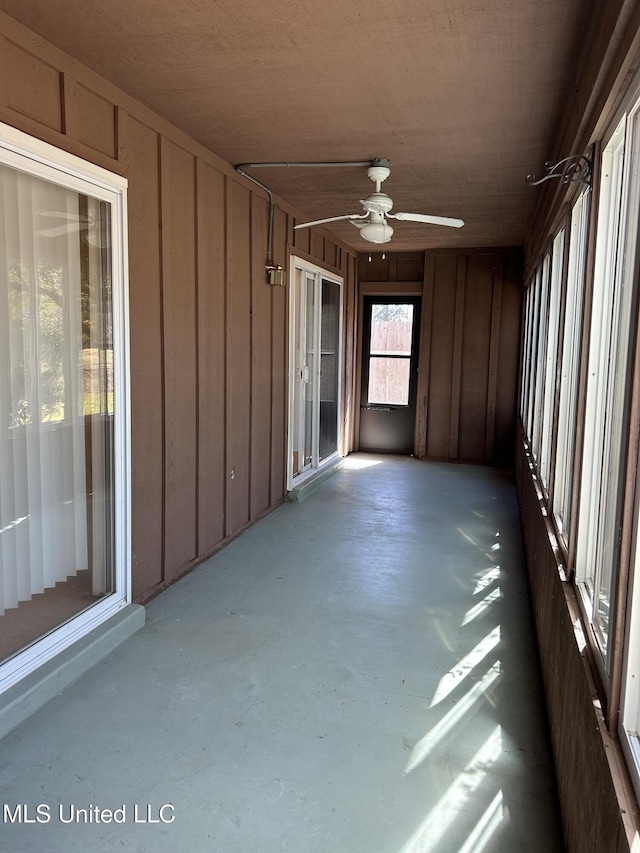 unfurnished sunroom featuring ceiling fan