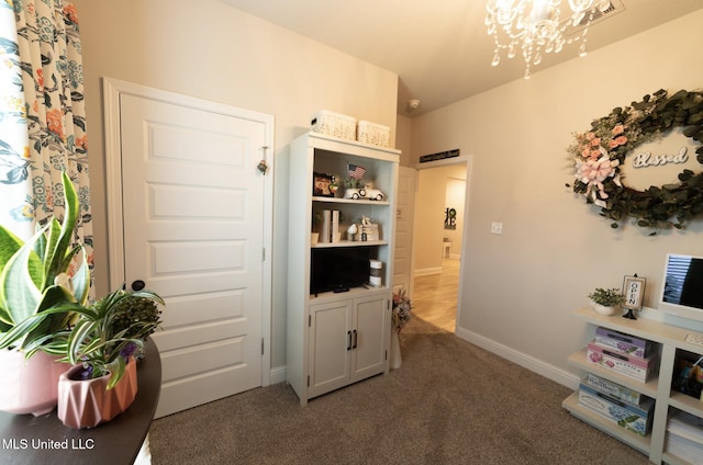 living area featuring an inviting chandelier, carpet floors, and baseboards