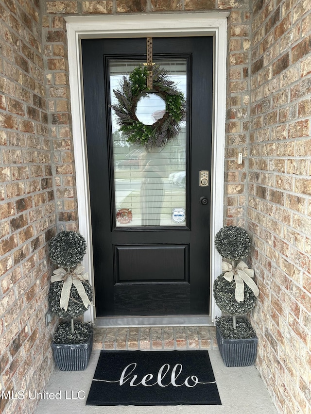 doorway to property featuring brick siding