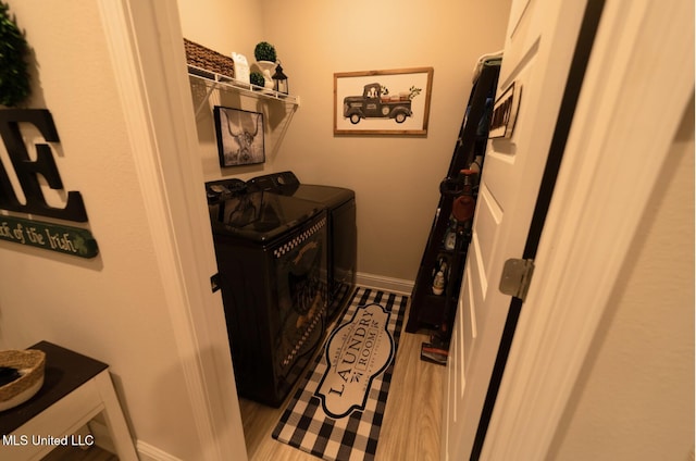 clothes washing area with laundry area, baseboards, and washing machine and clothes dryer