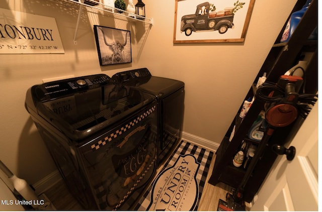 laundry room with baseboards, laundry area, and washing machine and clothes dryer