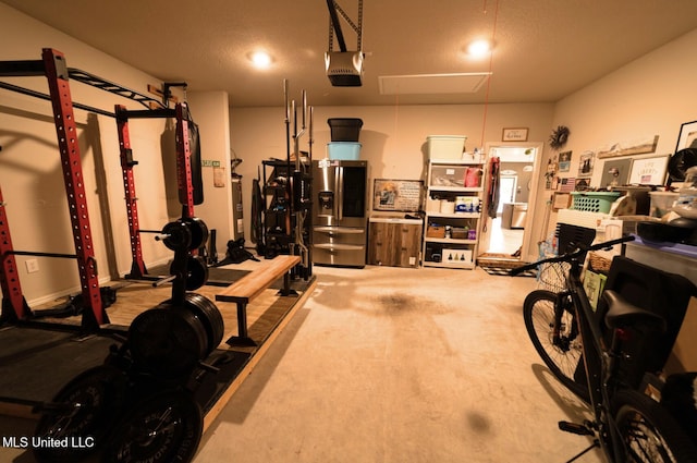 garage with stainless steel fridge and a garage door opener