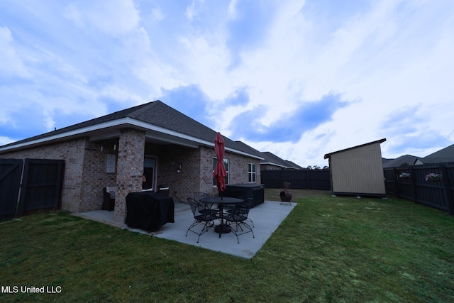 rear view of property with a lawn, a patio, a fenced backyard, and a shed