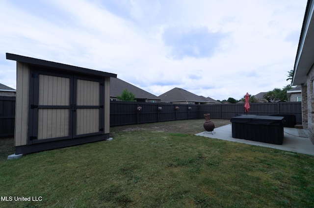 view of yard with a fenced backyard, a patio, and a storage shed