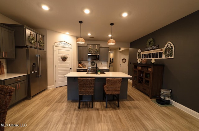 kitchen with light wood-style floors, light countertops, stainless steel appliances, baseboards, and recessed lighting