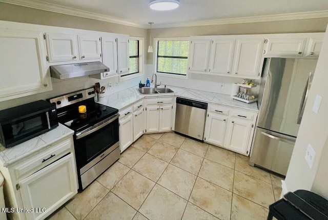 kitchen featuring appliances with stainless steel finishes, white cabinetry, sink, light tile patterned flooring, and crown molding