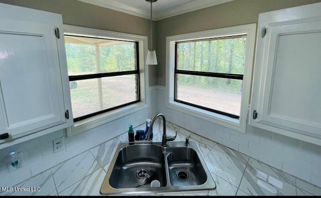 details featuring white cabinetry, decorative backsplash, light stone counters, and sink