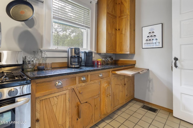 1704 N State St, Jackson, MS 39202 - kitchen featuring stainless steel range with gas cooktop, brown cabinets, and dark countertops