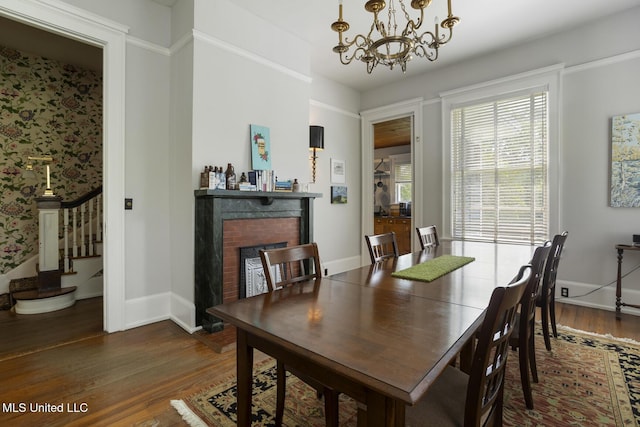 1704 N State St, Jackson, MS 39202 - dining area with wood finished floors, stairway, a chandelier, and a brick fireplace