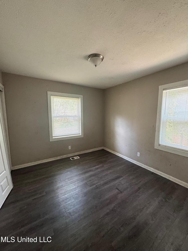 1870 Wisteria Dr, Jackson, MS 39204 - spare room featuring dark wood-type flooring, a textured ceiling, and baseboards
