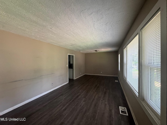 1870 Wisteria Dr, Jackson, MS 39204 - spare room with a textured ceiling, dark wood-type flooring, and baseboards