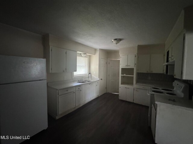 1870 Wisteria Dr, Jackson, MS 39204 - kitchen with freestanding refrigerator, under cabinet range hood, dark wood-style floors, white cabinetry, and a textured ceiling