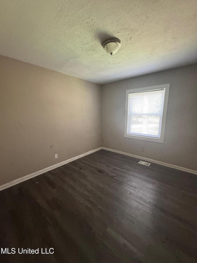 1870 Wisteria Dr, Jackson, MS 39204 - spare room with dark wood finished floors, a textured ceiling, and baseboards