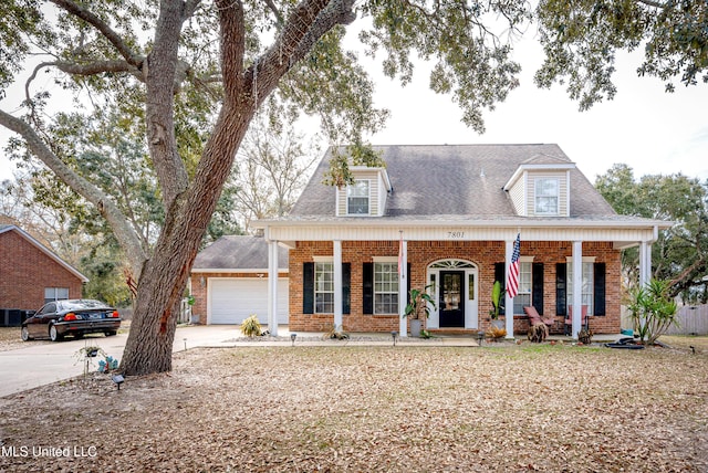 cape cod-style house featuring a garage and covered porch