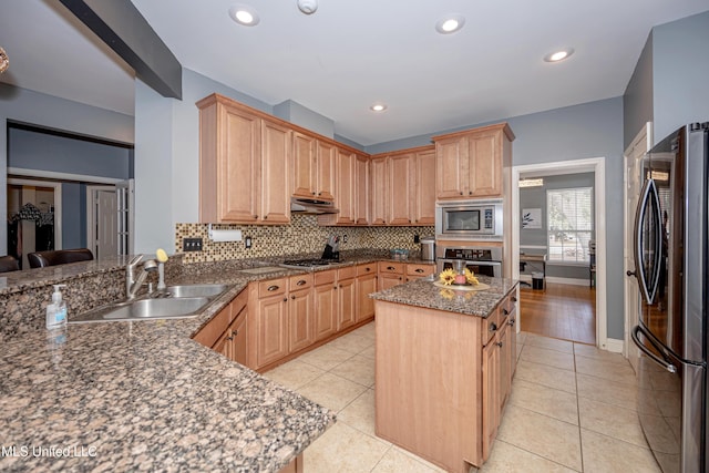 kitchen featuring a kitchen island, tasteful backsplash, sink, stainless steel appliances, and light brown cabinets