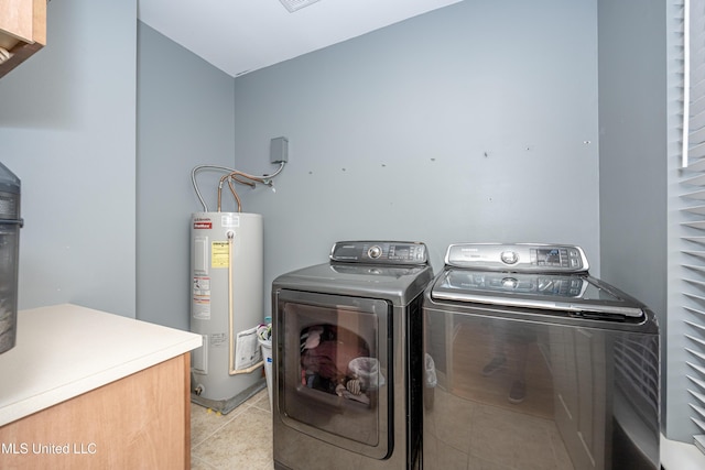 laundry room with water heater, light tile patterned flooring, and washer and clothes dryer