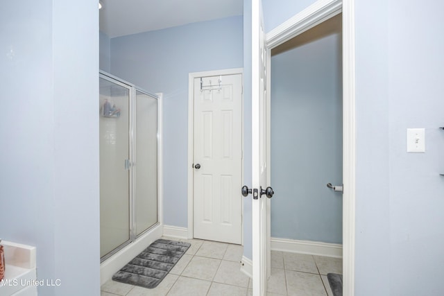 bathroom with tile patterned flooring and a shower with door