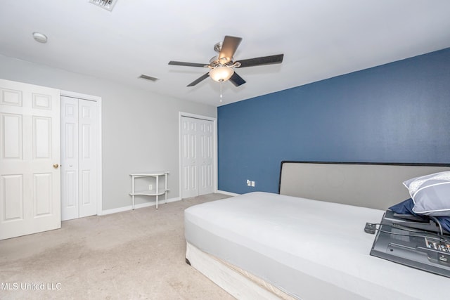 bedroom with carpet, two closets, and ceiling fan