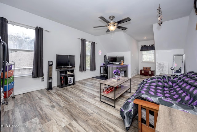 living room with ceiling fan, wood-type flooring, lofted ceiling, and plenty of natural light