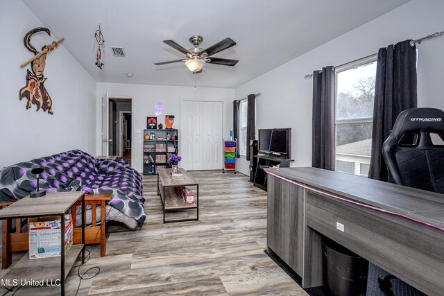 living room featuring ceiling fan and light hardwood / wood-style floors