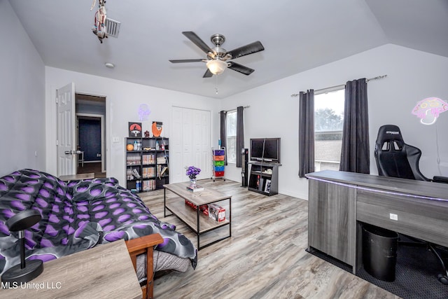 living room featuring lofted ceiling, ceiling fan, and light hardwood / wood-style flooring