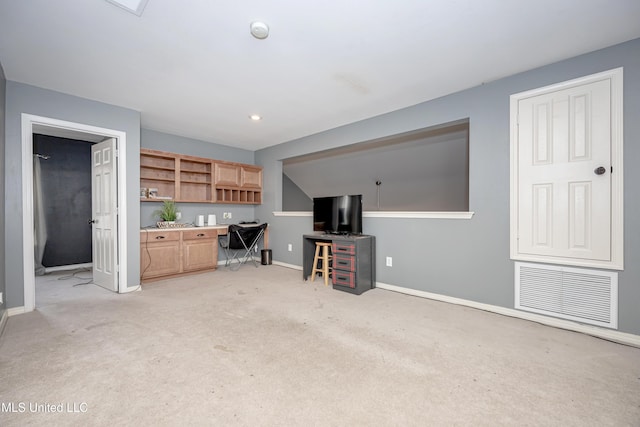 living room featuring built in desk and light carpet