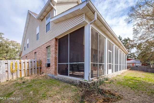 view of side of home with a yard and a sunroom