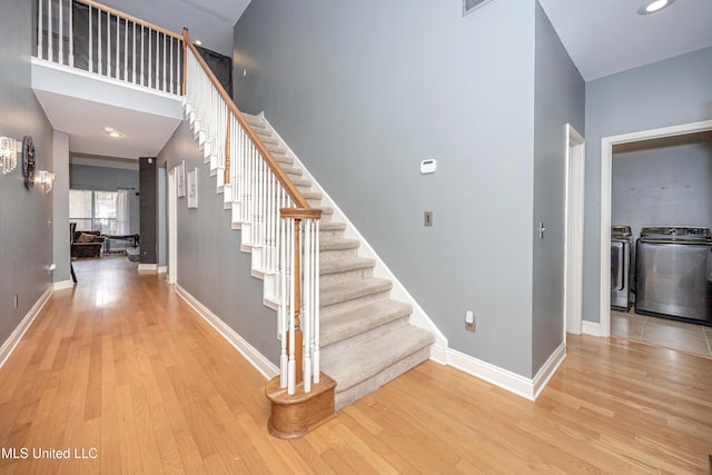 stairs featuring separate washer and dryer and hardwood / wood-style floors