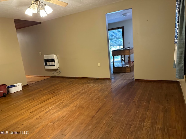 empty room with heating unit, ceiling fan, a textured ceiling, and hardwood / wood-style flooring