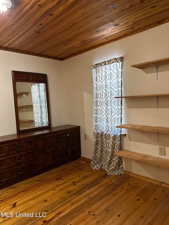 unfurnished bedroom featuring hardwood / wood-style floors, ornamental molding, and wooden ceiling