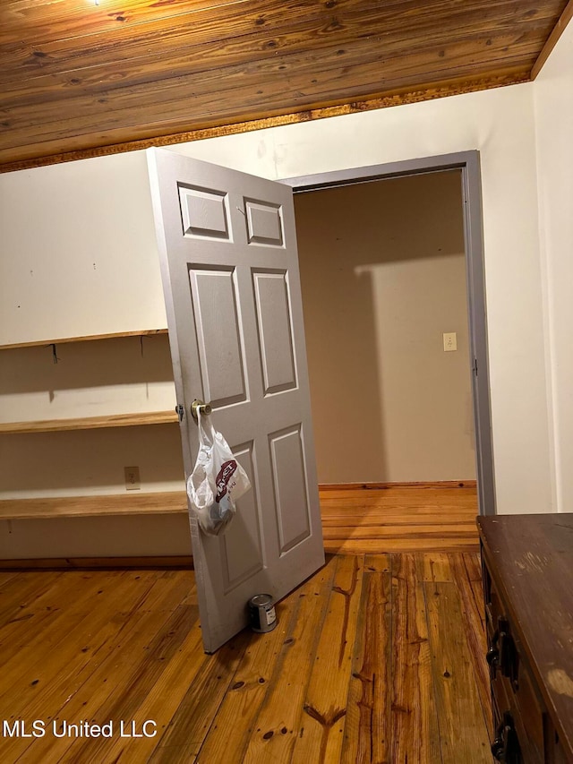 hall with wood-type flooring and wood ceiling