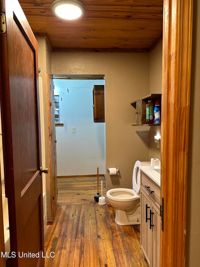 bathroom with hardwood / wood-style floors, vanity, wood ceiling, and toilet