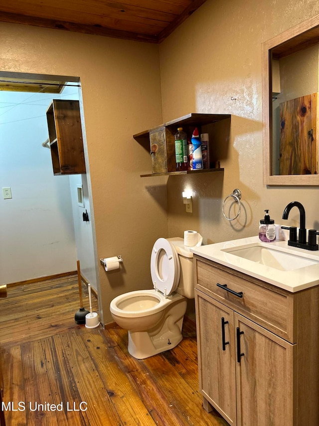 bathroom with hardwood / wood-style floors, vanity, wooden ceiling, and toilet