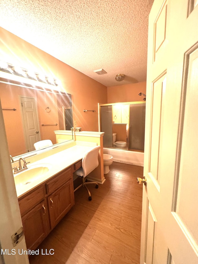 167 Tackett Run, Southaven, MS 38671 - bathroom featuring vanity, a textured ceiling, enclosed tub / shower combo, and wood finished floors