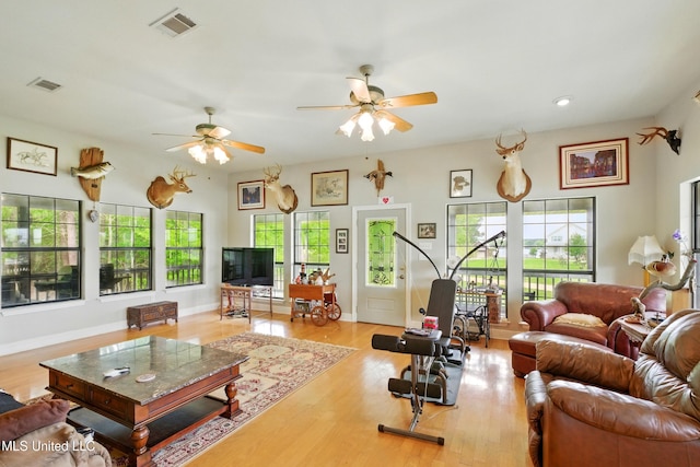 living room featuring a ceiling fan, a healthy amount of sunlight, and visible vents
