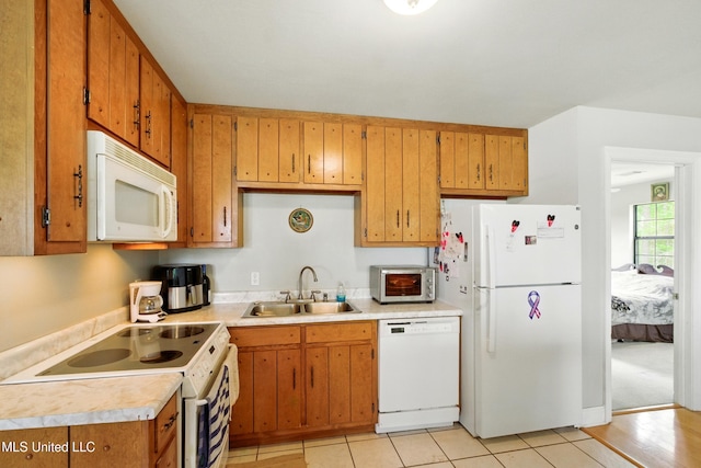 kitchen with light countertops, a sink, brown cabinetry, white appliances, and a toaster