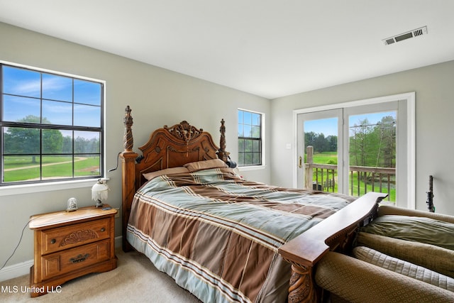 carpeted bedroom with access to outside, baseboards, visible vents, and multiple windows