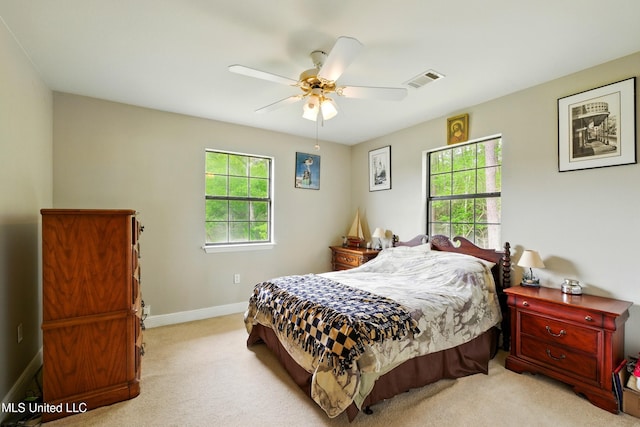 bedroom with light carpet, baseboards, multiple windows, and visible vents