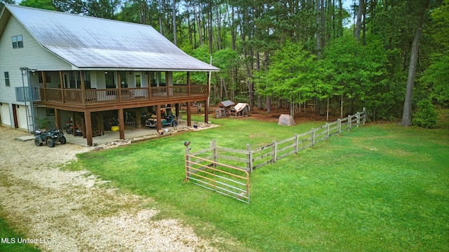 view of yard featuring a wooden deck, a garage, fence, and a patio