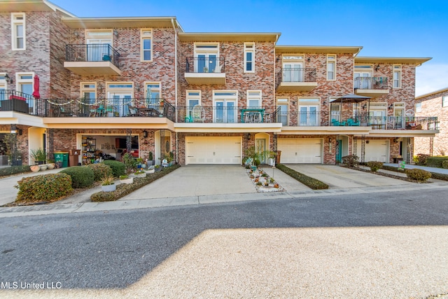 townhome / multi-family property featuring driveway, an attached garage, and brick siding