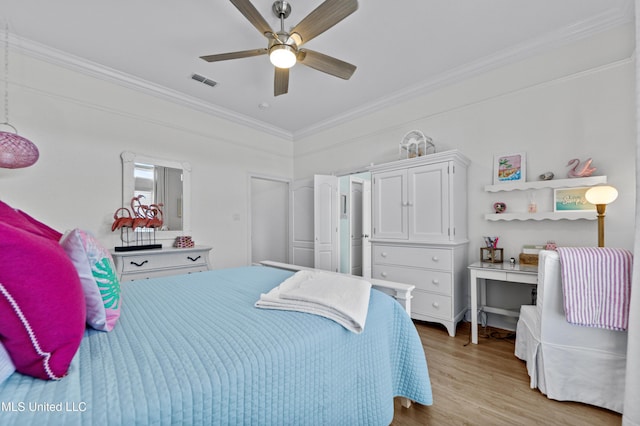 bedroom featuring light wood-style floors, visible vents, crown molding, and ceiling fan