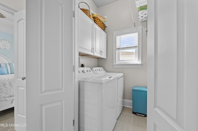 washroom with cabinet space, baseboards, light tile patterned flooring, and independent washer and dryer