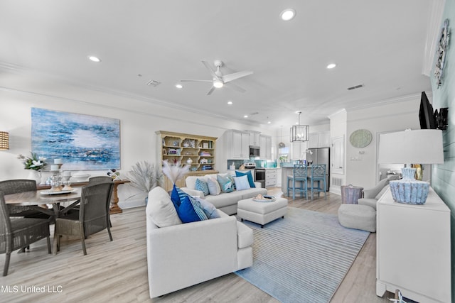 living area with ornamental molding, visible vents, and light wood finished floors