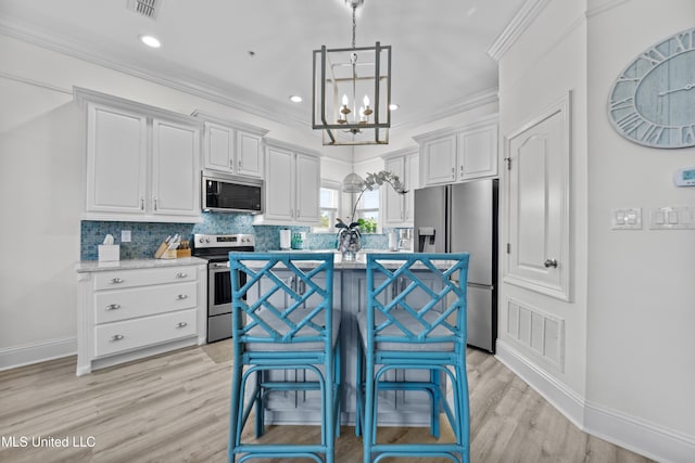 kitchen with stainless steel appliances, decorative backsplash, visible vents, and white cabinets