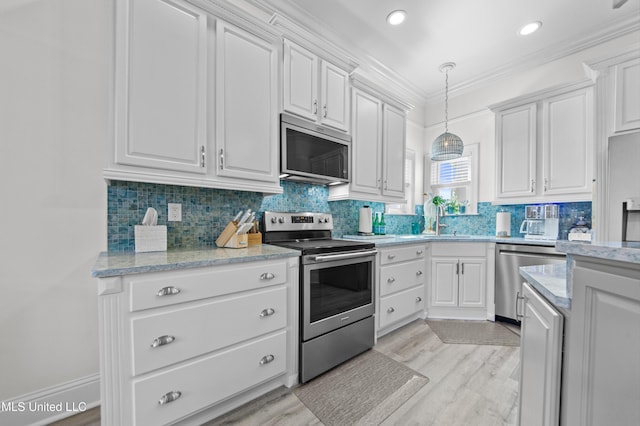 kitchen with white cabinetry, stainless steel appliances, and crown molding