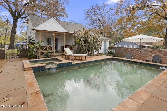 view of pool with ceiling fan, an in ground hot tub, and a wooden deck