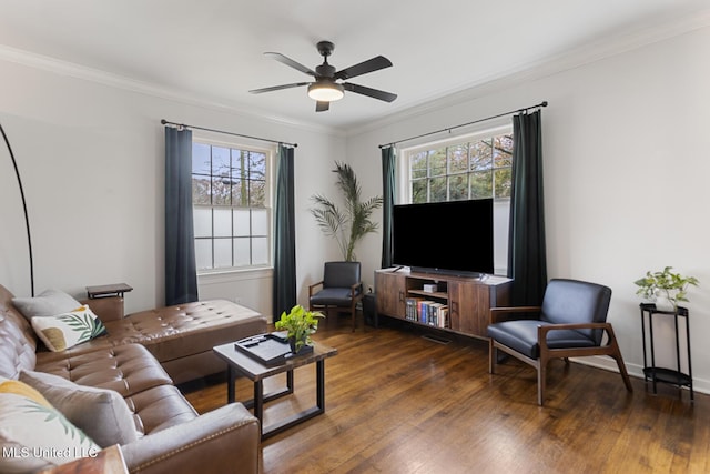 living room featuring dark hardwood / wood-style floors, ceiling fan, ornamental molding, and a wealth of natural light